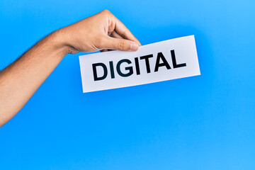 Hand of caucasian man holding paper with digital word over isolated blue background