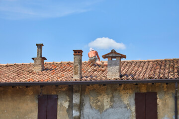 Old town impressions in an Italian village, where a roofer is repairing the roof Italy. 