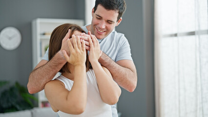 Beautiful couple surprise covering eyes with hands at home