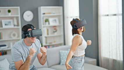 Beautiful couple playing dancing video game using virtual reality glasses at home
