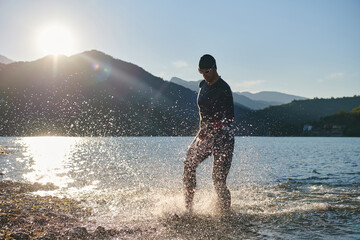 Triathlon athlete starting swimming training on lake