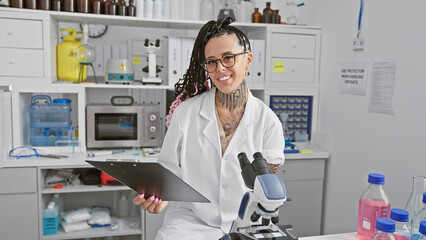 Confident and smiling, young hispanic woman scientist, beautifully works with clipboard in lab,...