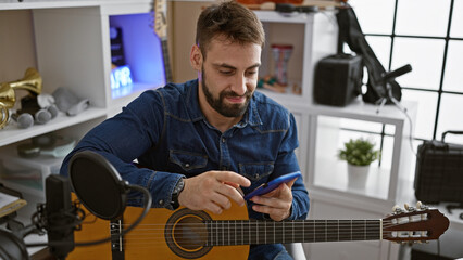 Handsome young hispanic man, an alluring musician tuning his classical guitar, typing chords on...