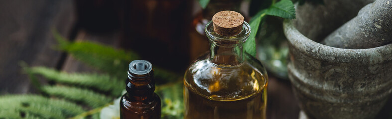 Concept of alternative herbal medicine. Bottles of tincture or potion, organic essential oils,...