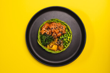 Appetizing bowl with salmon and vegetables sprinkled with sesame seeds