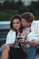 Private wedding for two in casual clothes on a roof top with skyscrapers and urban cityscape on background. Romantic marriage proposal on Saint Valentine's Day. Happy loving beautiful young couple