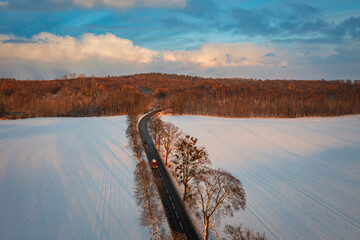 Aerial landscape of the road through snowy field at winter, Poland. - obrazy, fototapety, plakaty