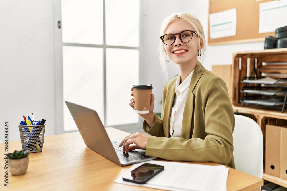 Poster Young blonde woman business worker using laptop drinking coffee at office