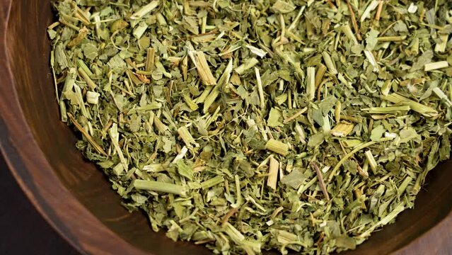 Passion flower dried herbs. Dry Passiflora incarnata in full wooden bowl. Alternative herbal medicine green ingredient. Rotation