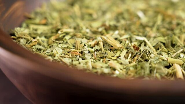 Passiflora dry leaves in wooden bowl. Dried Passion flower herbs close up for relaxation. Rotation