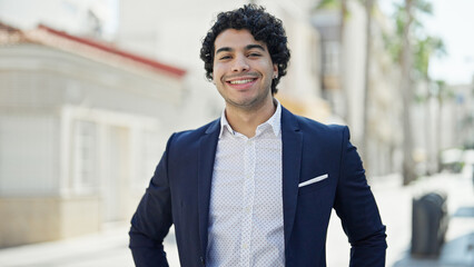 Young latin man business worker smiling confident standing at street