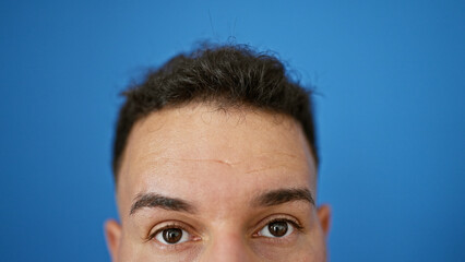 Young arab man close up of eyes over isolated blue background