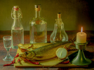 Still life in antique style with fish and alcohol on a wooden table. - 688211903