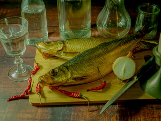 Still life in antique style with fish and alcohol on a wooden table. - 688211946