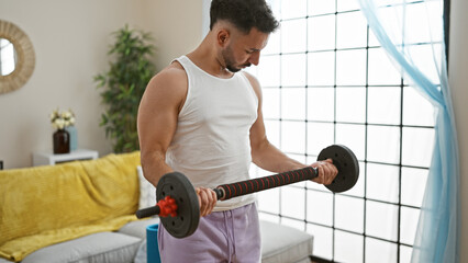 Young arab man using weight training at home