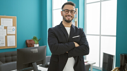 Young arab man business worker standing with arms crossed gesture smiling at the office
