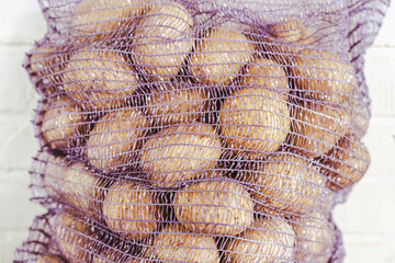 Rustic Scene of Fresh Potatoes in Mesh Bag on Wooden Table, Harvest Concept