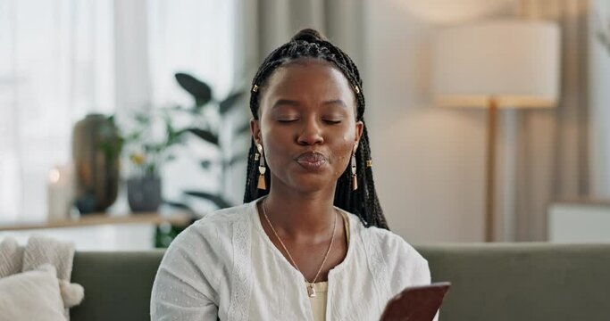 Home, eating and black woman on couch, chocolate bar and dessert with comfort food, relax and sugar snack in a lounge. African person, apartment or girl with candy, relaxing and dessert with cacao