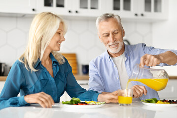 Cheerful Older Spouses Enjoying Healthy Breakfast Together In Kitchen