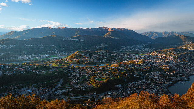 Wide-angle sunset view from the summit of Monte San Salvatore overlooking Lake Lugano Breathtaking panorama of the city, Melide causeway and the Swiss Alps in Ticino, Switzerland - November 2023