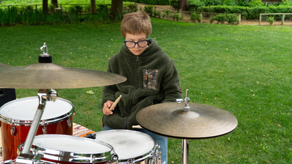 Capturing the joy of a young drummer with Down syndrome embracing the rhythm of his passion outside.