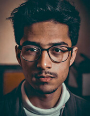 Portrait of a young man with glasses, old and dark photograph that conveys loneliness