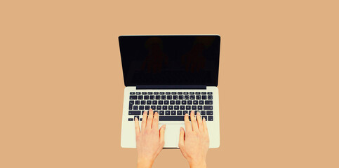Close up female hands woman working with laptop and blank black screen on brown background