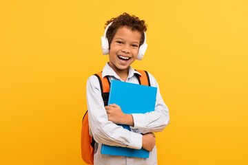 Boy with headphones and book, orange bag - obrazy, fototapety, plakaty