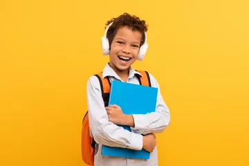 Poster Boy with headphones and book, orange bag © Prostock-studio