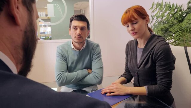 real estate agent gives clarification to a couple who want to buy a house