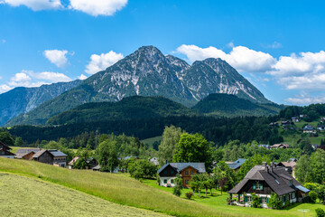 Beautiful idyllic panorama view of village near Altaussee with the peak Sarstein in background on a sunny summer day with blue sky cloud, Styria, Austria - 688220920
