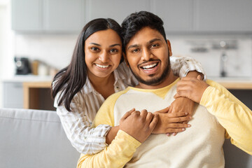 Obraz na płótnie Canvas Portrait Of Happy Young Indian Couple Hugging At Home