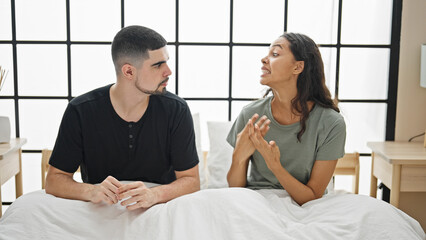 Beautiful couple arguing in bedroom, a serious disagreement amidst a lovely morning, stressed...