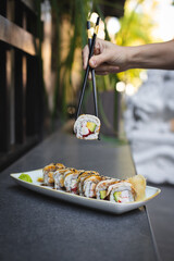 Sushi with wasabi and ginger on a black stone tray on a dark background. Mockup