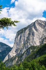 Stunning view of the steep cliff of Trisselwand above Altaussee lake on a sunny summer day with blue sky cloud, Salzkammergut-Ausseerland region, Styria, Austria - 688223993