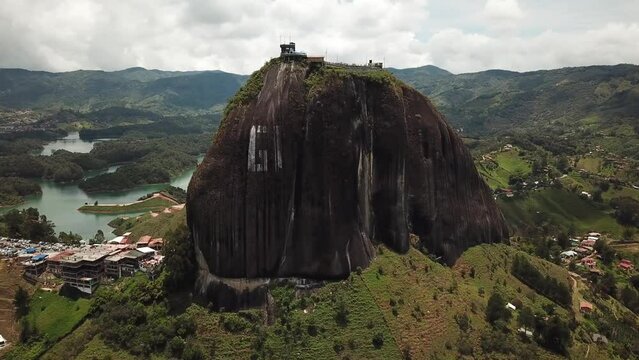 Aerial drone footage of El Penon de Guatape near Medellin in Antioquia, Colombia. Large and unique alone rock with stairs to the top, touristic place. Big stone in Colombia. High quality 4k footage.