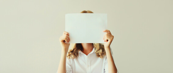 Woman showing and holding white blank sheet of paper document for advertising text blank copy space...