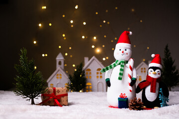 Holiday greeting card and background. Decorative snowman and penguin in the village