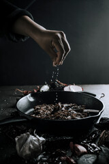 mano de persona mexicana agregando sal a platillo, cocina mexicana, birria.