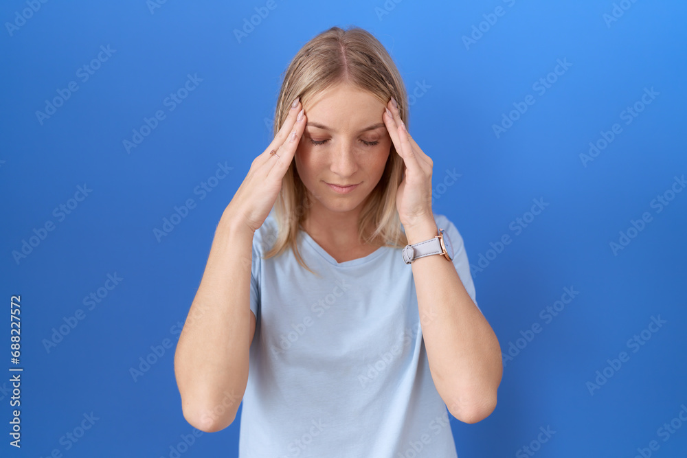 Canvas Prints Young caucasian woman wearing casual blue t shirt with hand on head, headache because stress. suffering migraine.