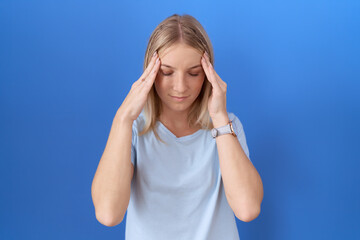 Fototapeta premium Young caucasian woman wearing casual blue t shirt with hand on head, headache because stress. suffering migraine.