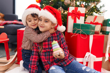 Adorable boy and girl hugging each other celebrating christmas at home