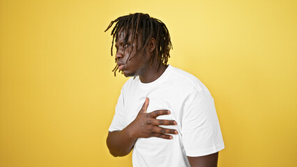 African american man coughing over isolated yellow background