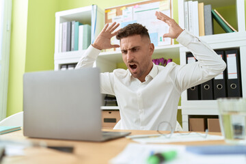 Fototapeta premium Young hispanic man business worker angry screaming at office