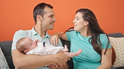Family of three bonding sitting on the sofa at home