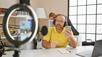 Attractive middle-aged caucasian man, a bearded musician giving a video call tutorial on music,...