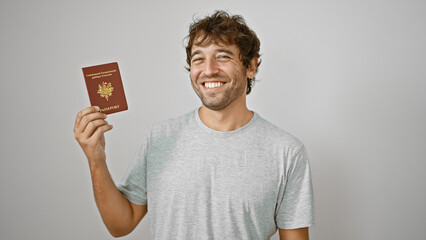 Joyful young hispanic man holding his french passport with confidence, standing isolated on a white...