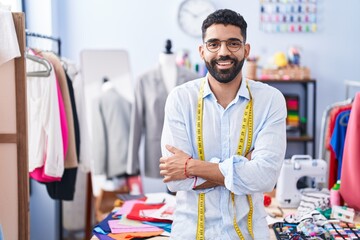 Young arab man tailor smiling confident standing with arms crossed gesture at tailor shop