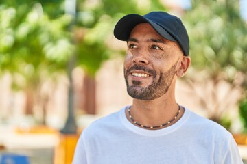 Young bald man smiling confident looking to the side at park