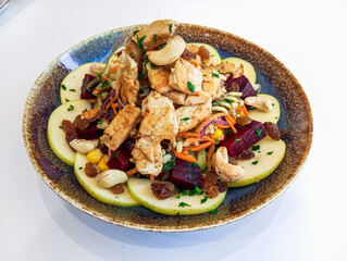 A plate of delicious and healthy vegetables salad. Moroccan modern vegetables salad with cooked chicken meat slices.